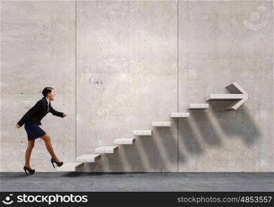 Up the career ladder. Businesswoman in suit stepping up stone staircase