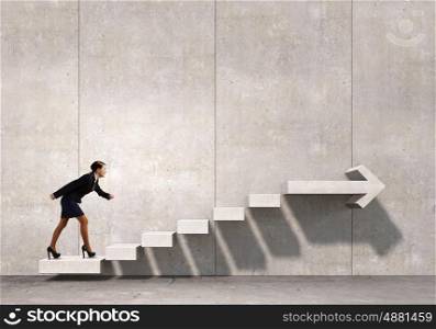 Up the career ladder. Businesswoman in suit stepping up stone staircase
