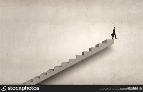 Up the career ladder. Young businessman on staircase top representing success concept