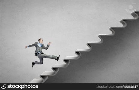 Up the career ladder. Young businessman running up on staircase representing success concept