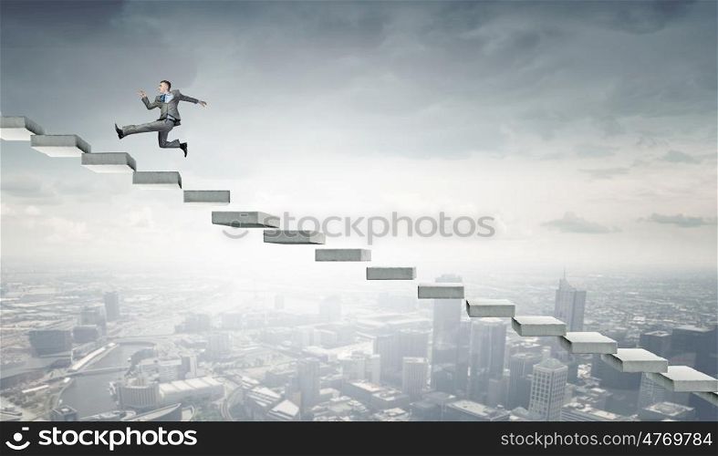 Up the career ladder. Young businessman running up on staircase representing success concept