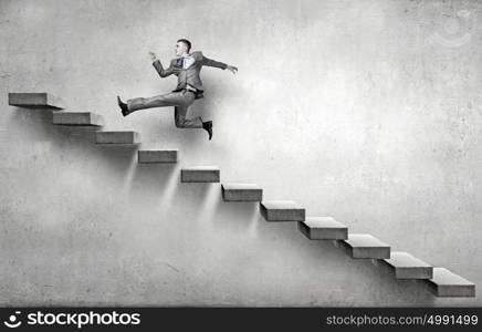 Up the career ladder. Young businessman walking up on staircase representing success concept