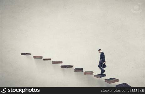 Up the career ladder. Young businessman walking up staircase representing success concept