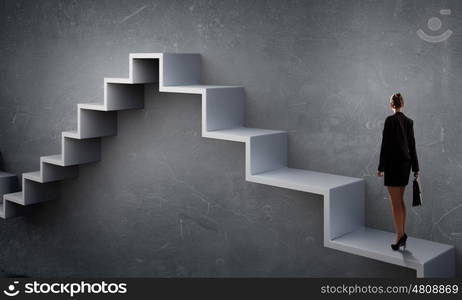 Up the career ladder. Young businesswoman reaching up staircase as symbol of growth and progress