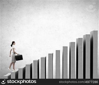 Up the career ladder. Young businesswoman walking up on staircase representing success concept