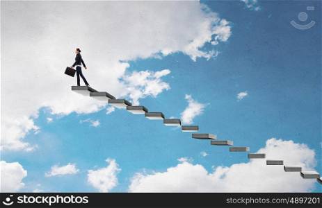 Up the career ladder. Young businesswoman walking up staircase representing success concept