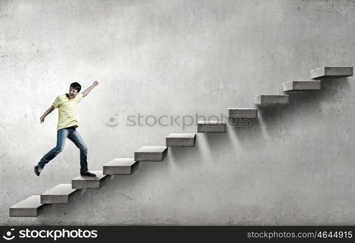 Up the career ladder. Young man walking up on staircase representing success concept