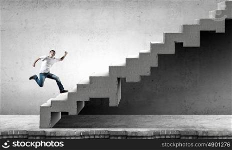 Up the career ladder. Young man walking up on staircase representing success concept