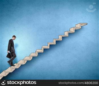 Up the career ladder. Young tired businessman walking up on staircase representing success concept