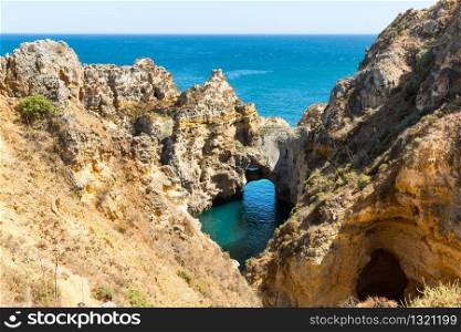 Up view of ocean shore with cliffs, Portugal. Ocean with rocky cliffs