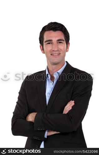 Upbeat businessman with arms folded