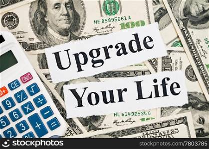 Upgrade your life, words and calculator on hundreds US notes background