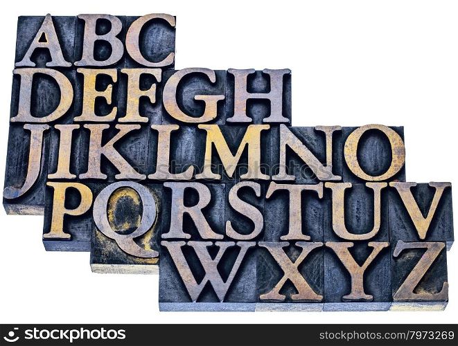 uppercase English alphabet in vintage letterpress wood type printing blocks stained by blue and yellow inks