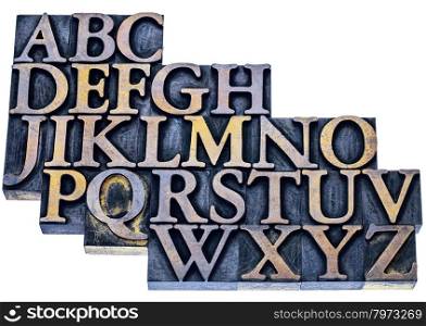 uppercase English alphabet in vintage letterpress wood type printing blocks stained by blue and yellow inks