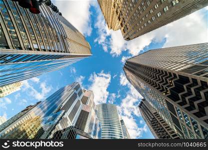 Uprisen angle with fisheye scene of Downtown Chicago skyscraper with reflection of clouds among high buildings which have airplane flying over the sky, Illinois, United States, Business and Perspective concept