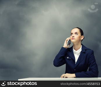 Upset businesswoman. Young upset businesswoman talking on mobile phone