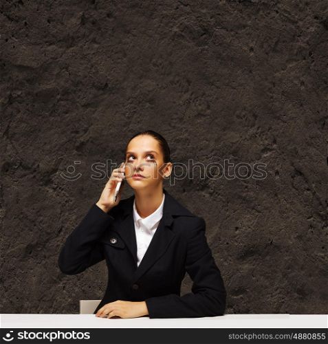 Upset businesswoman. Young upset businesswoman talking on mobile phone