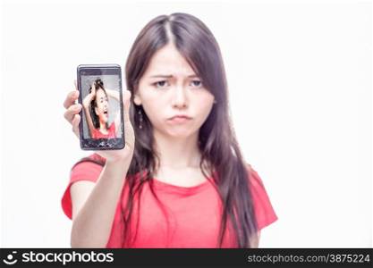 Upset Chinese woman, OOF, holding cracked cell phone with herself on screen screaming, frustration, trapped concept