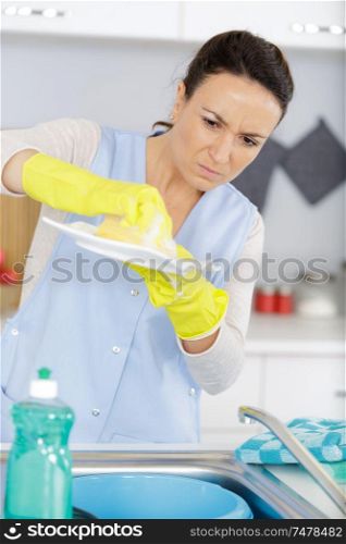 upset housewife woman washing dishes in kitchen