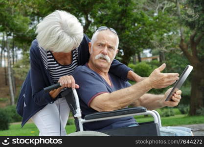 upset senior patient using digital tablet outdoor