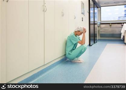 Upset surgeon sitting alone after she failed an operation