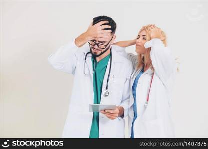 Upset surgical doctor and GP doctor on white background. Medical failure and malpractice concept.. Two upset doctors. A medical failure concept.