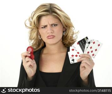 Upset young woman with bad poker hand and credit card. Poker chips in other hand.