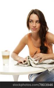 upset young woman with newspaper and latte macchiato at a table. upset young woman with newspaper and latte macchiato at a table on white background