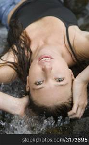 Upside down view of Caucasian young adult woman lying in fresh water.