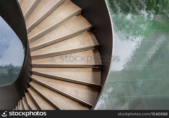 Upside view of a spiral staircase pattern. Spiral stairs circle in courtyard architecture. Outdoor ladder decoration interior. Selective focus.