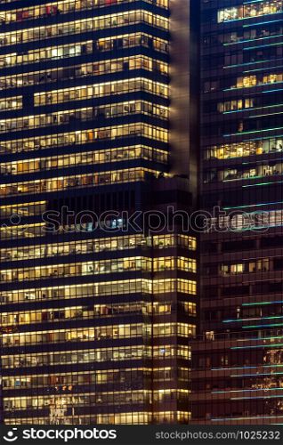 Urban abstract - window facade of business center office building with reflections and colours at night. Hong Kong China