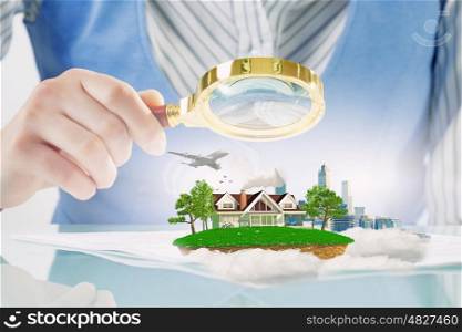Urban and suburban life. Close view of woman examining with magnifying glass architectural projects
