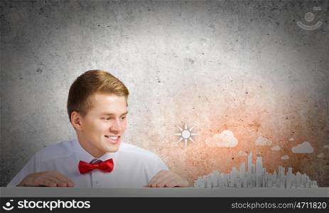 Urban construction. Young man pointing at modern city model