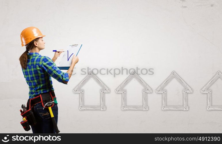 Urban construction. Young woman builder with folder in hand