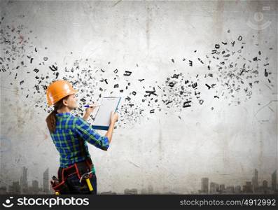 Urban construction. Young woman builder with folder in hand