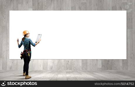 Urban construction. Young woman builder with folder in hand