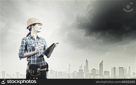 Urban construction. Young woman builder with projects in hand