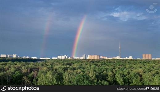 urban landscape with double rainbow under city park