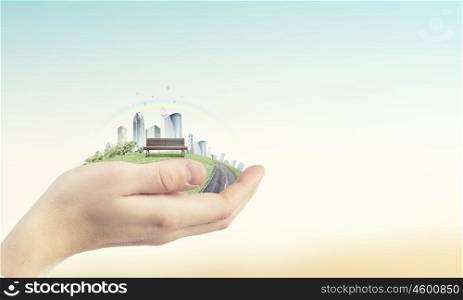 Urban life. Close up of hands holding image of modern cityscape