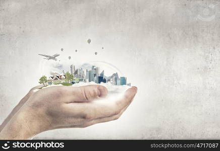 Urban life. Close up of hands holding image of modern cityscape