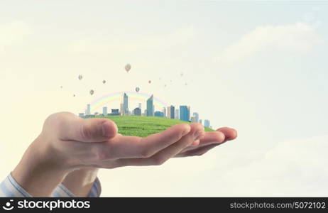 Urban life. Close up of hands holding image of modern cityscape