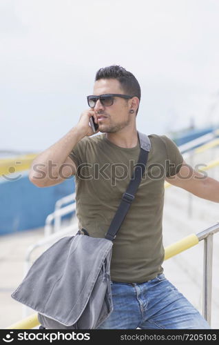 Urban man using a phone wearing sunglasses outdoors