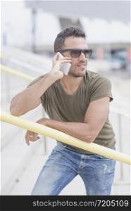 Urban man using a phone wearing sunglasses outdoors