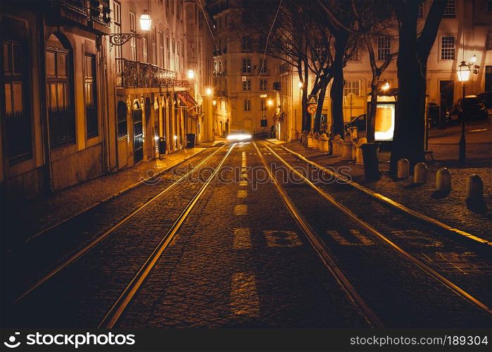 Urban night scene. Old European city illuminated street at night, Lisbon, Portugal