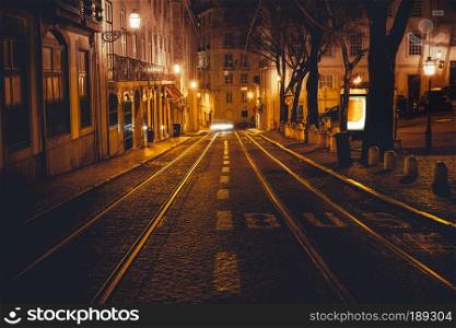 Urban night scene. Old European city illuminated street at night, Lisbon, Portugal