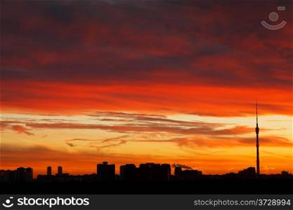 urban panorama with dramatic dark red sunrise sky over urban houses