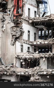 Urban scene. Dismantling of a house. Building demolition and crashing by machinery for new construction. Industry.