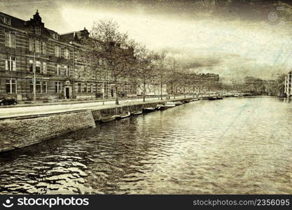 Urban scene in Amsterdam with typical local architecture. Embankment in the historical center of Amsterdam in the Netherlands. Vintage style toned picture