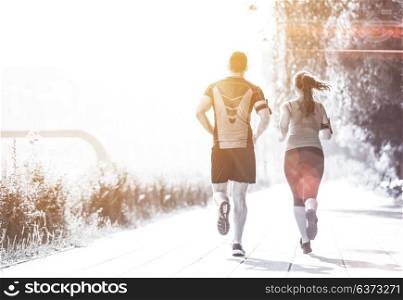 urban sports, healthy young couple jogging in the city at sunny morning