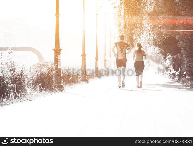 urban sports, healthy young couple jogging in the city at sunny morning